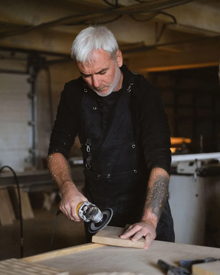 Artisan debout à son établi, en atelier