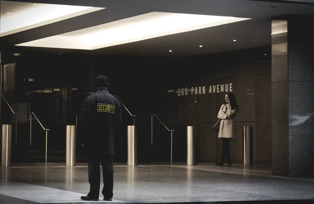 Agent de sécurité en poste debout dans un hall d'immeuble